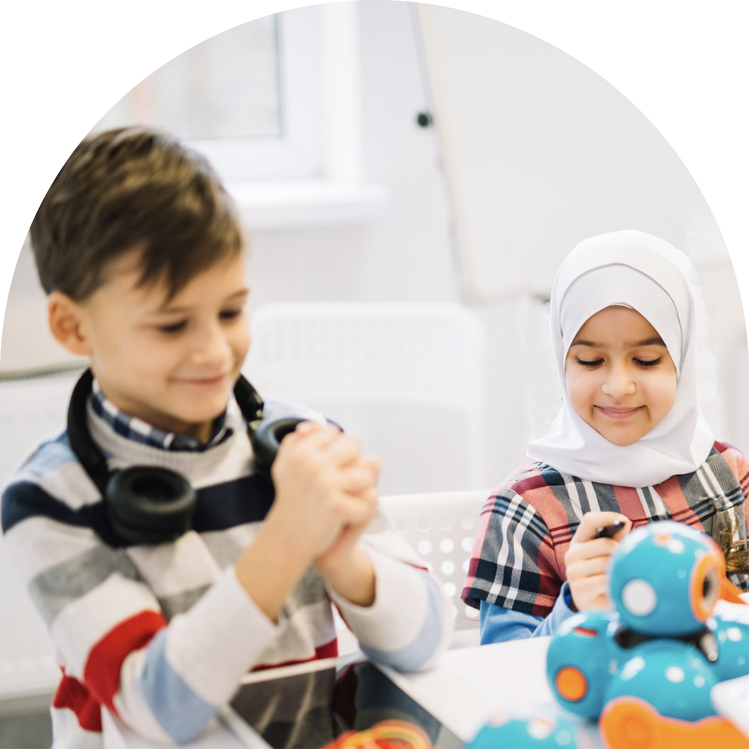 Two children engaging with educational robots at a table.